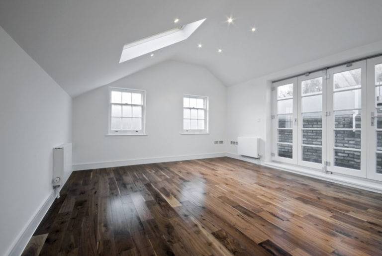 Large open white room with shined wooden floor