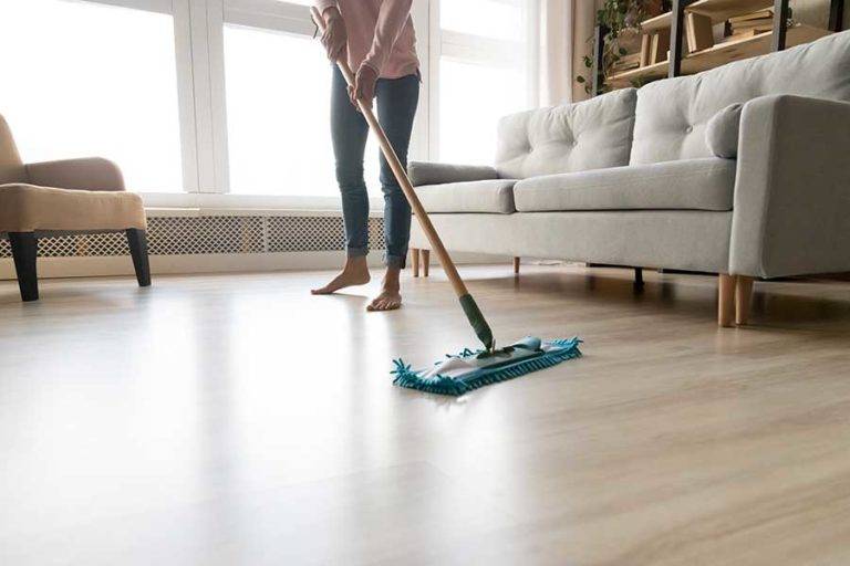 person cleaning laminate flooring